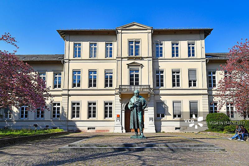德国海德堡：阳光明媚，历史悠久的弗里德里希大楼前的罗伯特·威廉·本生纪念碑图片素材