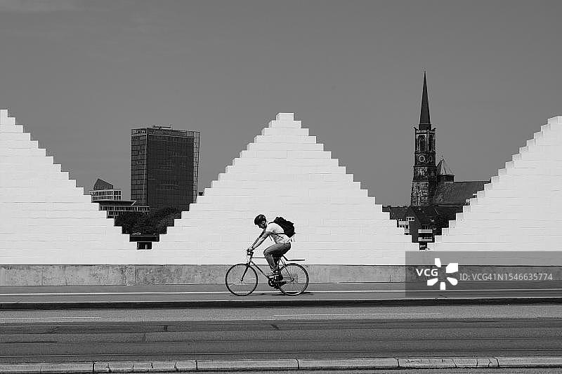 德国不莱梅汉萨市：白色墙壁、教堂和高楼前的骑行者图片素材