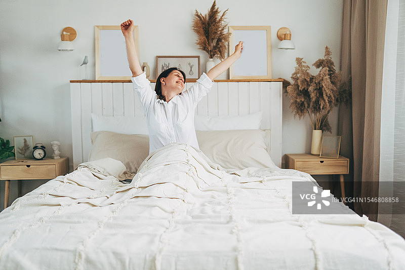 清晨在床上伸懒腰的女人图片素材