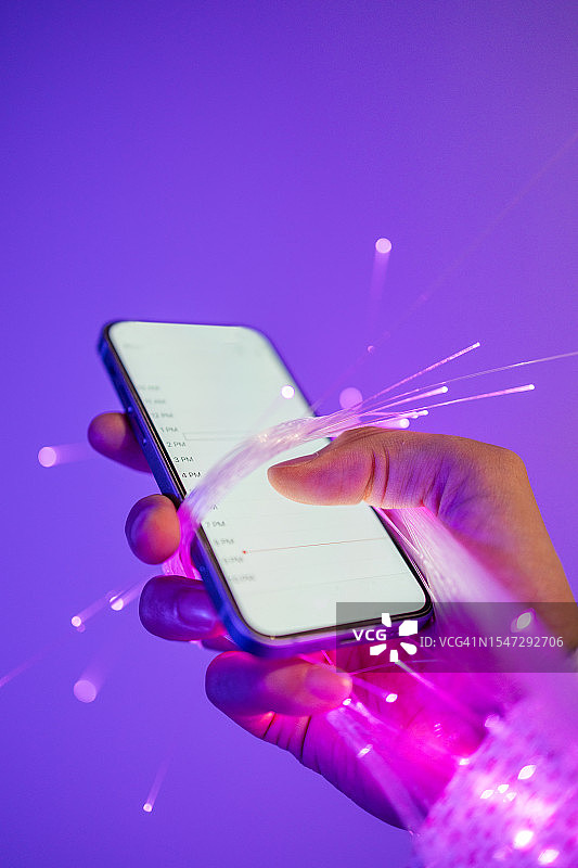 手持智能手机和光纤特写图片素材