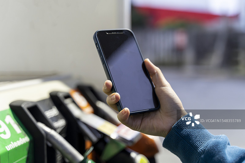 人们在加油站线上支付图片素材