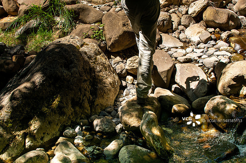沿着山间小溪行走的女人脚部的低视角图片素材