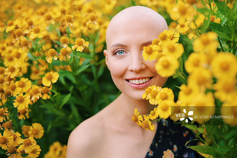 特写镜头下黄花丛中的年轻女孩肖像，身患乳腺癌或脱发症，战胜疾病图片素材