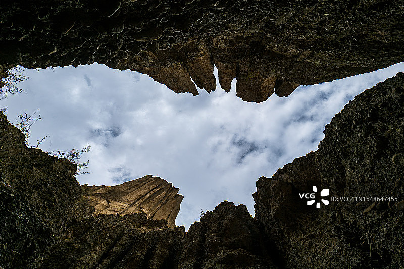 玻利维亚拉巴斯幽灵谷洞穴中蝙蝠形孔洞所见多云天空图片素材