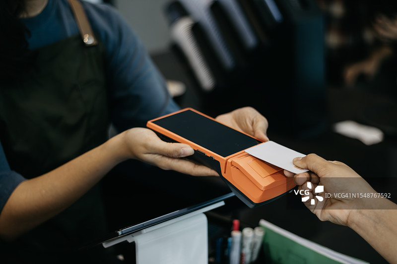 使用非接触式银行卡和终端支付特写图片素材