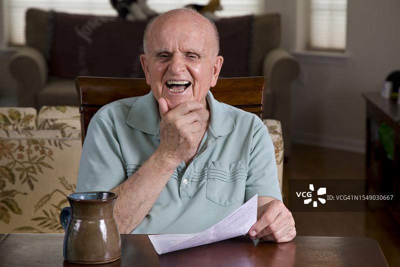 在家看着镜头大笑的年长男人图片素材