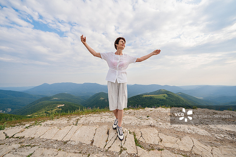 在山顶享受自由的年长女性图片素材