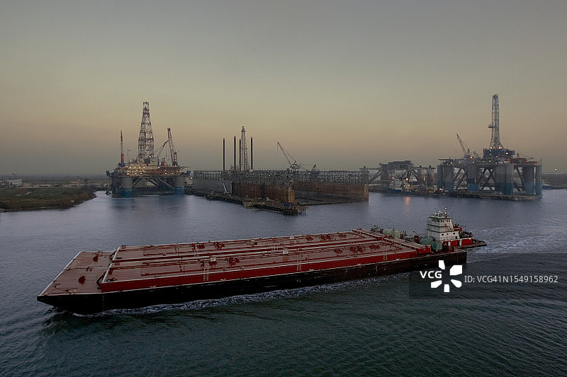 通过海上钻井平台建设的石化驳船图片素材
