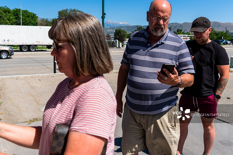 阳光明媚的ATM取款：排队的男士和女士图片素材