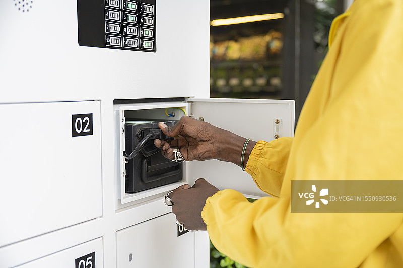 非洲骑手更换电动摩托车电池图片素材