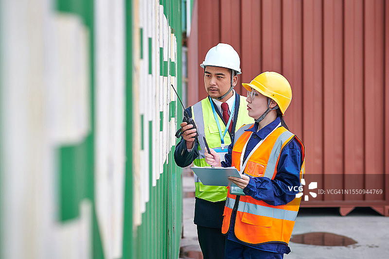 两位亚洲同事在货运集装箱处检查信息图片素材