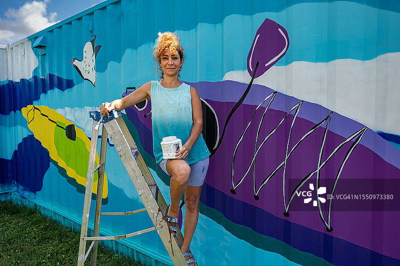 中年伊朗女艺术家在集装箱上绘制壁画图片素材