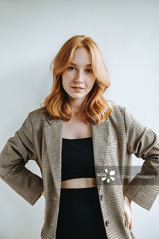 红发美女叉腰站立在白色背景前图片素材