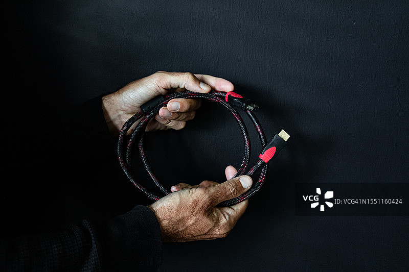 男人拿着一根HDMI线图片素材