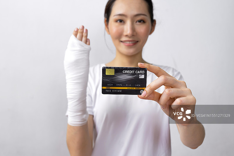 患者微笑著手持信用卡和医保卡，不用担心治疗费用图片素材