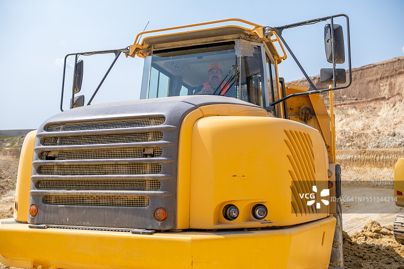 重型卡车司机在高岭土采石场图片素材
