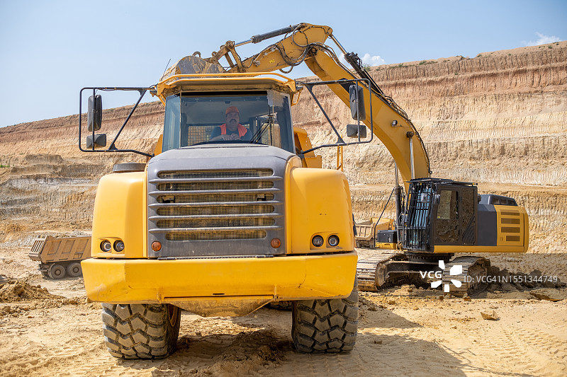 重型卡车司机在高岭土采石场图片素材