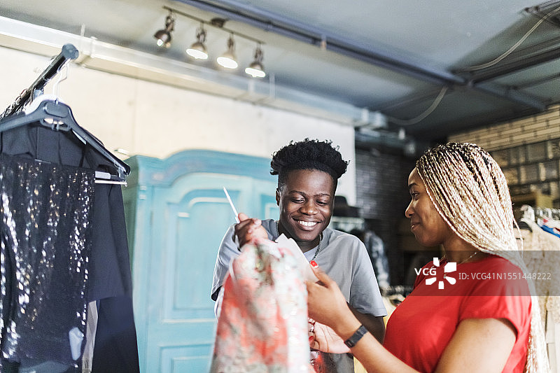 年轻的非洲夫妇在二手店挑选连衣裙图片素材