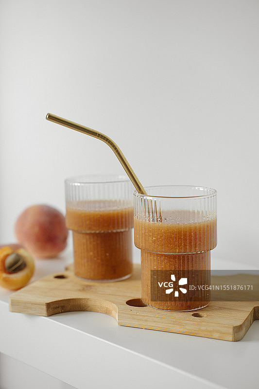 白色桌上木制托盘里的两杯自制杏桃冰沙图片素材