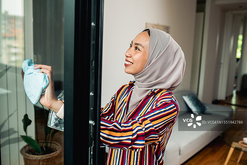 在家清洁窗户的快乐女人肖像图片素材