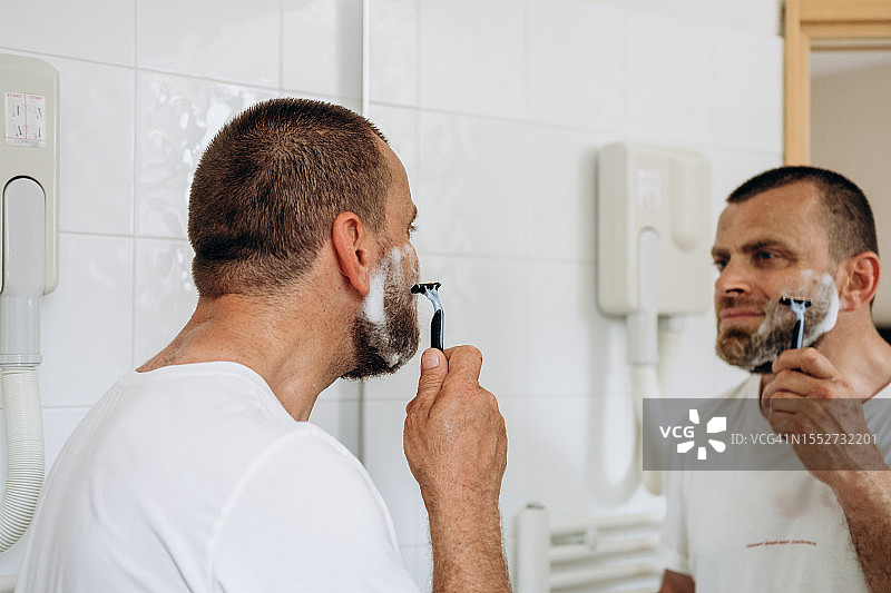 刮胡子的迷人男子，男士皮肤和面部护理图片素材
