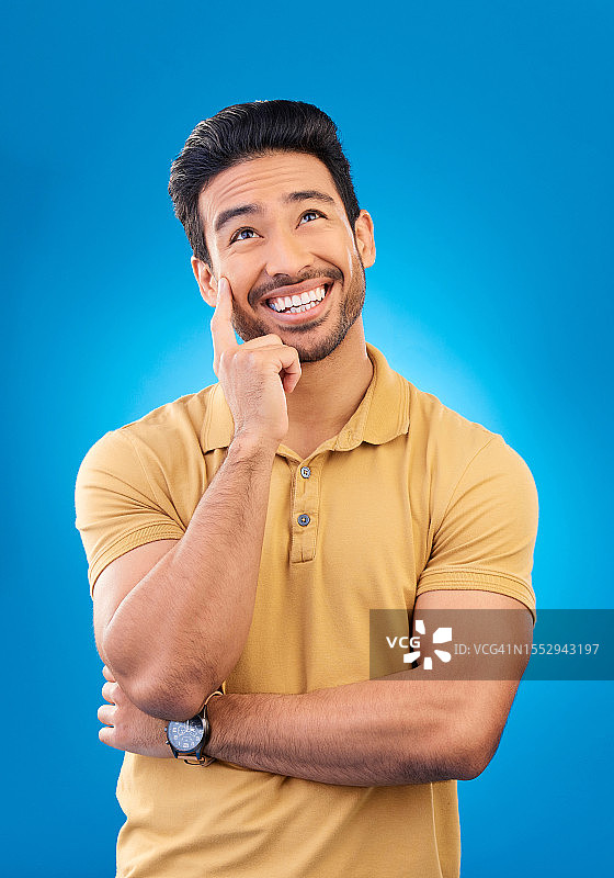 蓝色背景上的亚洲男子：关于灵感、计划与发展的头脑风暴图片素材