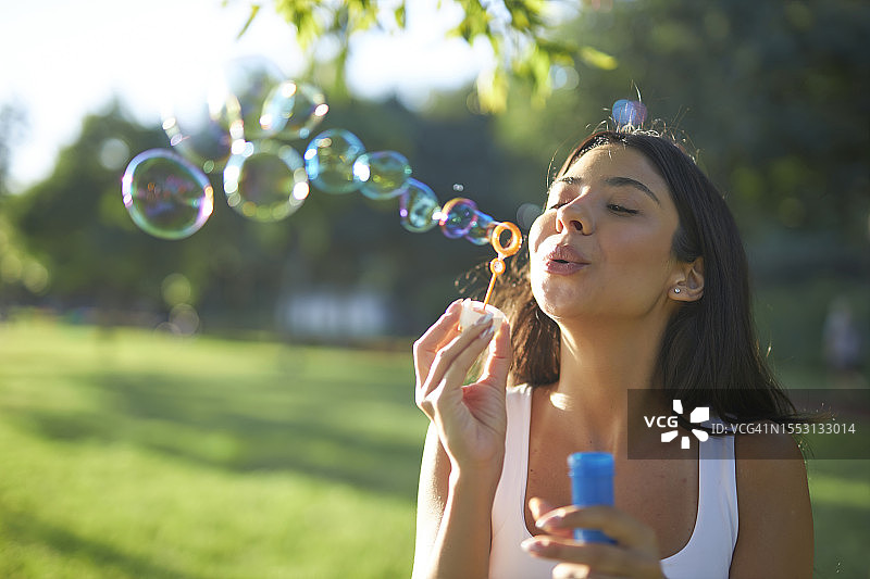 吹泡泡的有魅力棕发女性特写图片素材