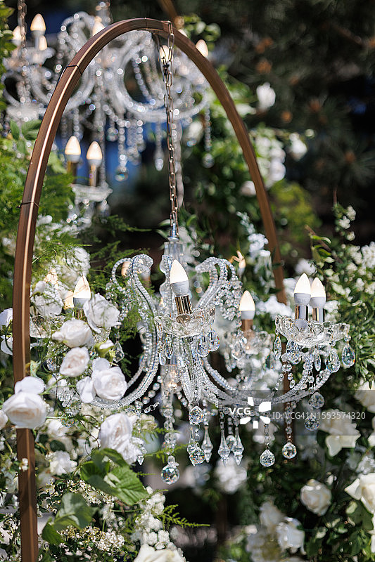 婚礼拱门上装饰着白色鲜花的美丽水晶吊灯图片素材