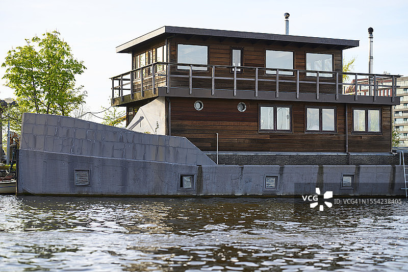 阿姆斯特丹运河中停泊的带窗户的船只外观（侧视图）图片素材