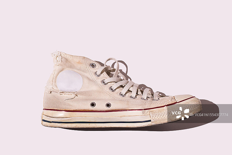 白色背景上的复古风旧篮球鞋：现代休闲运动概念图片素材