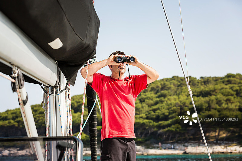 在帆船上拿着望远镜的水手图片素材