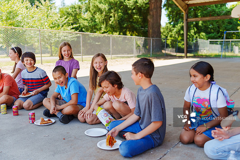 在户外吃午餐的小学生图片素材