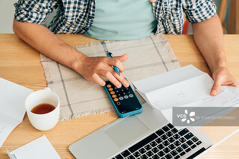 使用计算器分析财务数据的男人图片素材