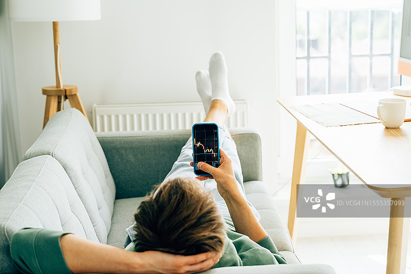 手机投资理财新方式：用户通过手机投资股市，关注股票图表图片素材