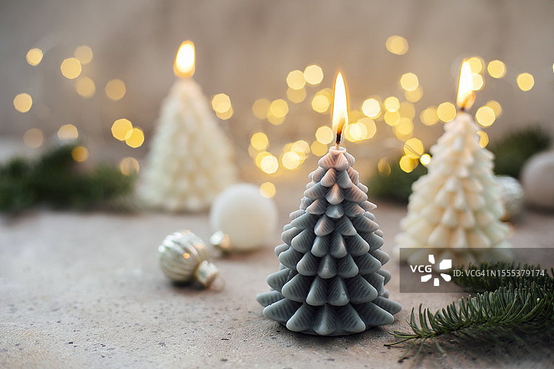 棕色背景上树形的灰色和米色燃烧蜡烛，圣诞节、冬季、新年卡片图片素材