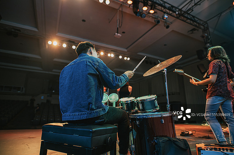 年轻亚裔乐队在舞台上表演后视图图片素材