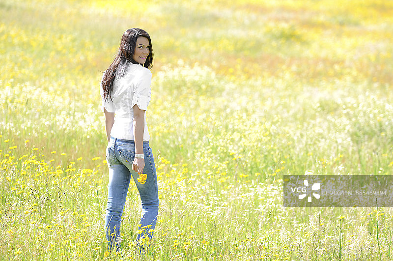 在黄色花田中散步的女人图片素材