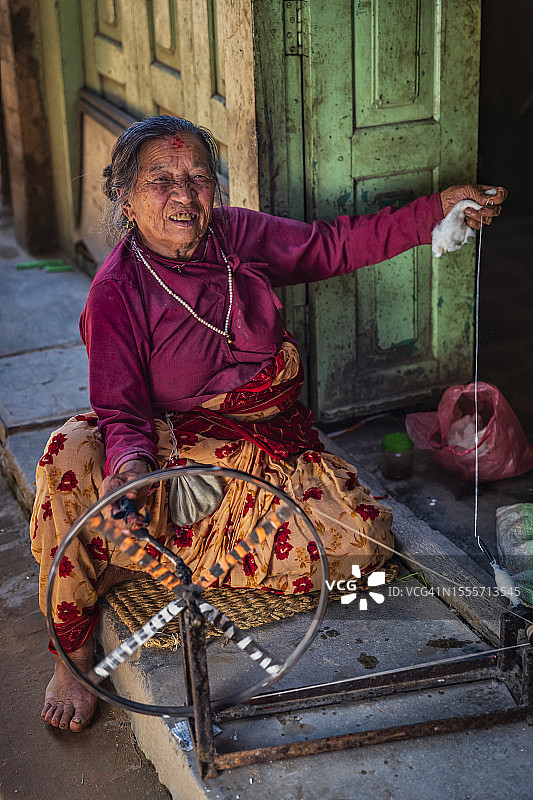 尼泊尔妇女在尼泊尔巴克塔普尔古镇纺羊毛图片素材