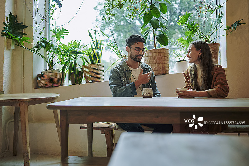 约会期间，在咖啡馆交谈的微笑青年男人和女人图片素材