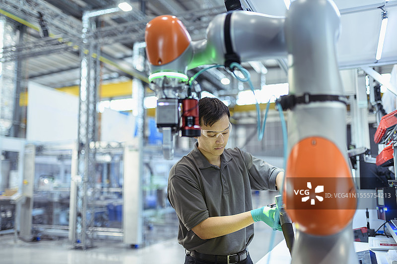 在数字化工厂中使用协作机器人的工程师图片素材