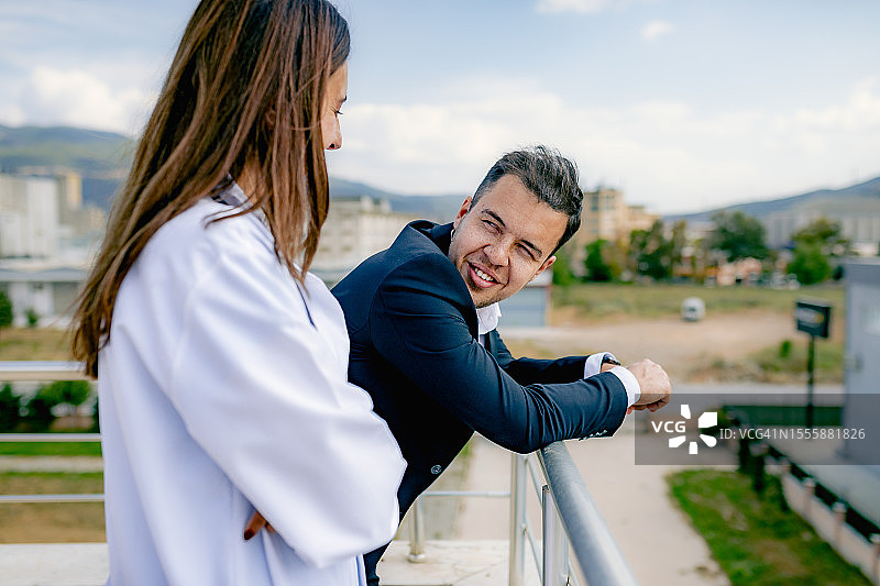 屋顶休憩：商务主管与年轻女医生交谈图片素材