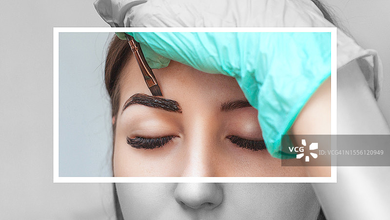 化妆师为年轻女孩的眉毛染色，进行专业化妆和皮肤护理图片素材