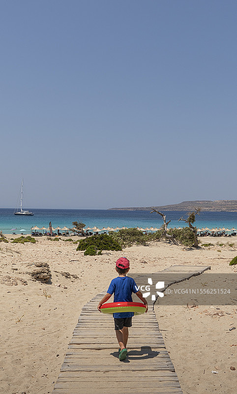 带着游泳圈去海滩的男孩图片素材
