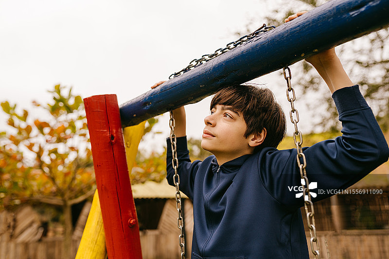 操场上沉思的青少年男孩图片素材
