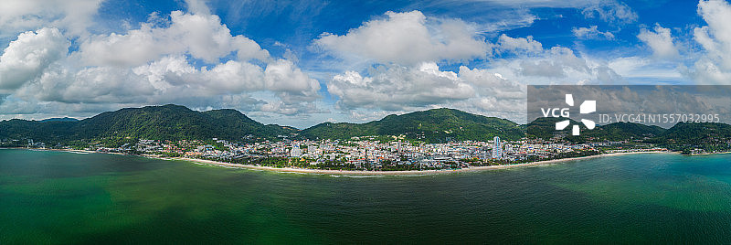 芭东海滩全景鸟瞰图，有许多游客和驾驶水上摩托艇的游客及绿色山景建筑图片素材