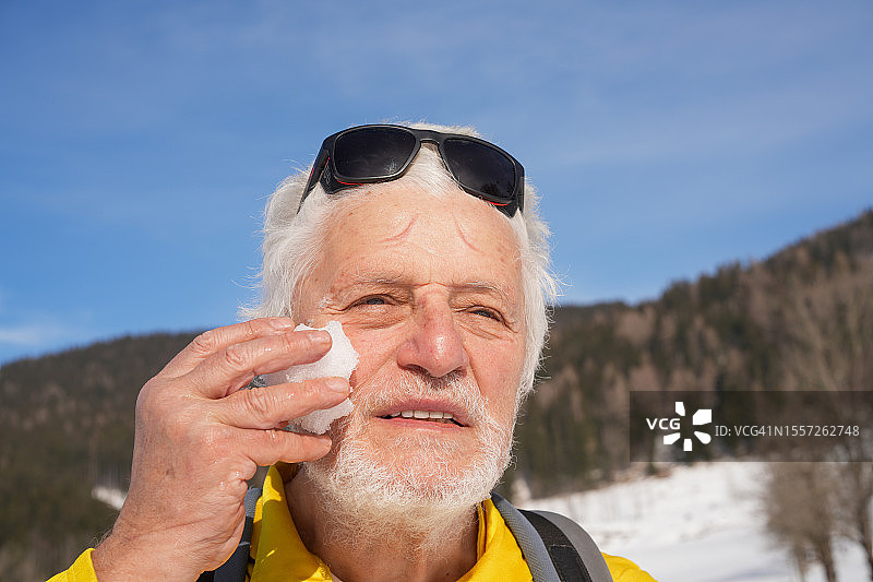 帕金森病患者在斯洛文尼亚越野滑雪时用雪降温的肖像图片素材