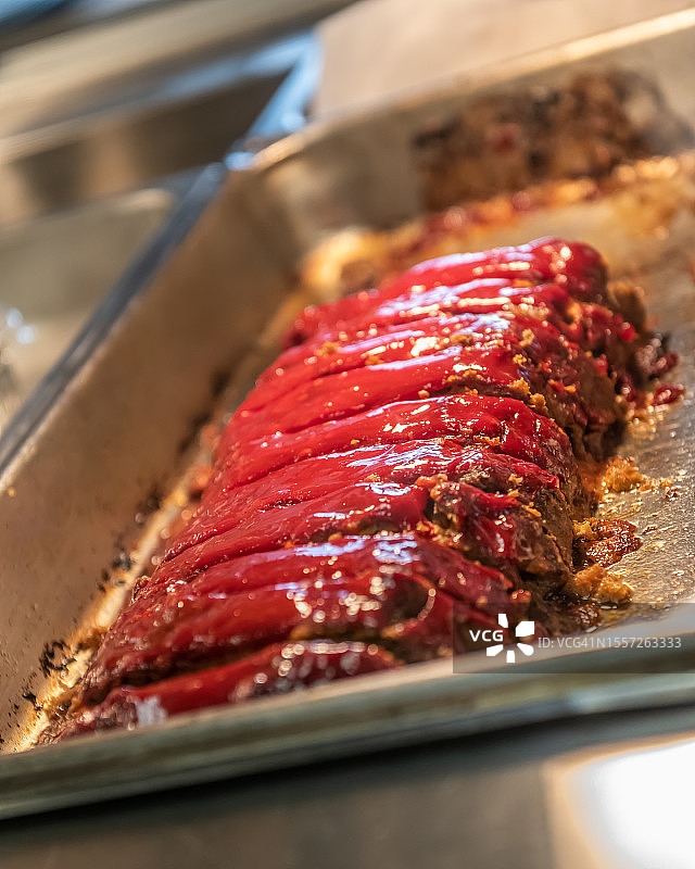 餐馆玻璃后保温托盘中待售的肉饼特写图片素材
