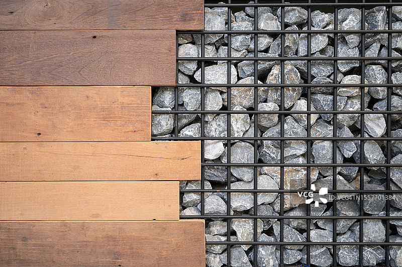 木墙与金属笼中的石堆：自然的平衡图片素材