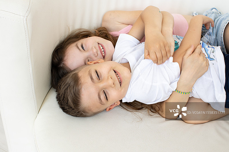 快乐的儿童在沙发上拥抱图片素材