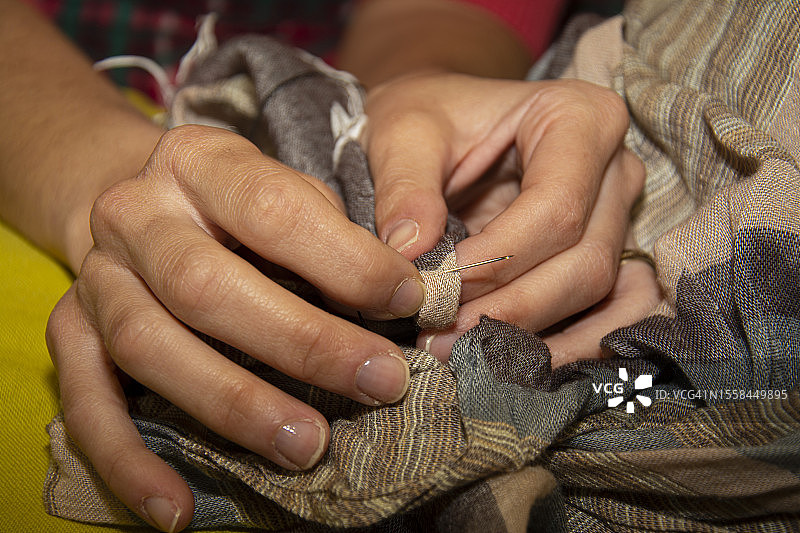 在意大利用针缝制衣服的手图片素材